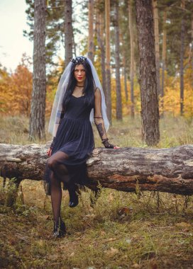 Karanlık bir ormanda cadılar bayramı cadısı. Modern cadılar gibi giyinmiş güzel bir kadın. Cadılar Bayramı sanat tasarımı. Cadılar Bayramı Konsepti için karanlık tema