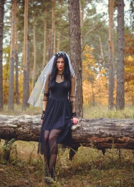 Karanlık bir ormanda cadılar bayramı cadısı. Modern cadılar gibi giyinmiş güzel bir kadın. Cadılar Bayramı sanat tasarımı. Cadılar Bayramı Konsepti için karanlık tema