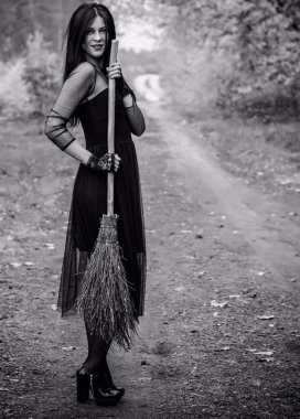 Karanlık bir ormanda cadılar bayramı cadısı. Modern cadılar gibi giyinmiş güzel bir kadın. Cadılar Bayramı sanat tasarımı. Cadılar Bayramı Konsepti için karanlık tema