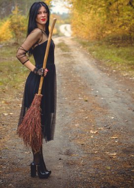 Karanlık bir ormanda cadılar bayramı cadısı. Modern cadılar gibi giyinmiş güzel bir kadın. Cadılar Bayramı sanat tasarımı. Cadılar Bayramı Konsepti için karanlık tema