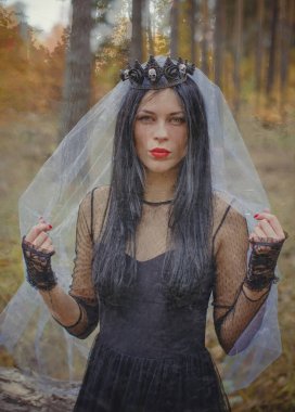 Karanlık bir ormanda cadılar bayramı cadısı. Modern cadılar gibi giyinmiş güzel bir kadın. Cadılar Bayramı sanat tasarımı. Cadılar Bayramı Konsepti için karanlık tema