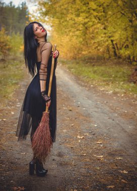 Karanlık bir ormanda cadılar bayramı cadısı. Modern cadılar gibi giyinmiş güzel bir kadın. Cadılar Bayramı sanat tasarımı. Cadılar Bayramı Konsepti için karanlık tema