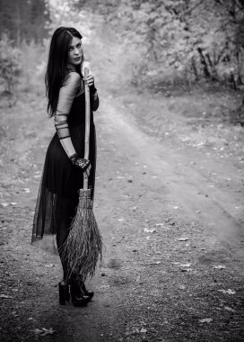 Karanlık bir ormanda cadılar bayramı cadısı. Modern cadılar gibi giyinmiş güzel bir kadın. Cadılar Bayramı sanat tasarımı. Cadılar Bayramı Konsepti için karanlık tema