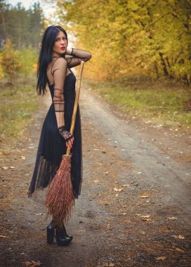 Karanlık bir ormanda cadılar bayramı cadısı. Modern cadılar gibi giyinmiş güzel bir kadın. Cadılar Bayramı sanat tasarımı. Cadılar Bayramı Konsepti için karanlık tema