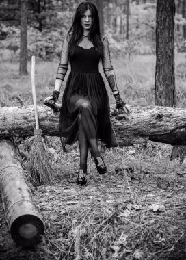 Karanlık bir ormanda cadılar bayramı cadısı. Modern cadılar gibi giyinmiş güzel bir kadın. Cadılar Bayramı sanat tasarımı. Cadılar Bayramı Konsepti için karanlık tema