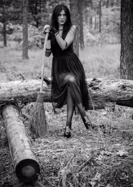 Karanlık bir ormanda cadılar bayramı cadısı. Modern cadılar gibi giyinmiş güzel bir kadın. Cadılar Bayramı sanat tasarımı. Cadılar Bayramı Konsepti için karanlık tema