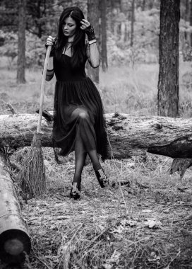 Karanlık bir ormanda cadılar bayramı cadısı. Modern cadılar gibi giyinmiş güzel bir kadın. Cadılar Bayramı sanat tasarımı. Cadılar Bayramı Konsepti için karanlık tema