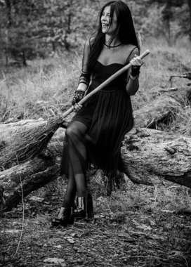 Karanlık bir ormanda cadılar bayramı cadısı. Modern cadılar gibi giyinmiş güzel bir kadın. Cadılar Bayramı sanat tasarımı. Cadılar Bayramı Konsepti için karanlık tema