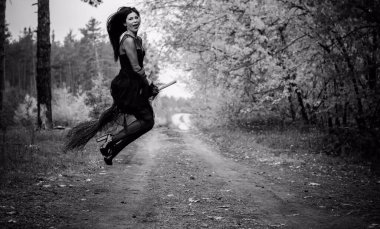 Karanlık bir ormanda cadılar bayramı cadısı. Modern cadılar gibi giyinmiş güzel bir kadın. Cadılar Bayramı sanat tasarımı. Cadılar Bayramı Konsepti için karanlık tema