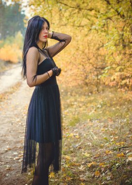 Karanlık bir ormanda cadılar bayramı cadısı. Modern cadılar gibi giyinmiş güzel bir kadın. Cadılar Bayramı sanat tasarımı. Cadılar Bayramı Konsepti için karanlık tema