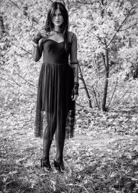 Karanlık bir ormanda cadılar bayramı cadısı. Modern cadılar gibi giyinmiş güzel bir kadın. Cadılar Bayramı sanat tasarımı. Cadılar Bayramı Konsepti için karanlık tema