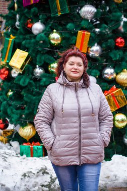 Noel, kış tatili konsepti. Güzel, büyük beden bir kadın yürüyor. Kadınlar için sevgi ve barış, olgun kadınların psikolojisi ve yaşam tarzı