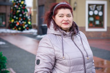 Noel, kış tatili konsepti. Güzel, büyük beden bir kadın yürüyor. Kadınlar için sevgi ve barış, olgun kadınların psikolojisi ve yaşam tarzı