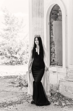 Bayana Cadılar Bayramı kıyafeti. Siyah modern elbiseli güzel bir genç kadın. Cadılar Bayramı sanat tasarımı. Cadılar Bayramı Konsepti için karanlık tema