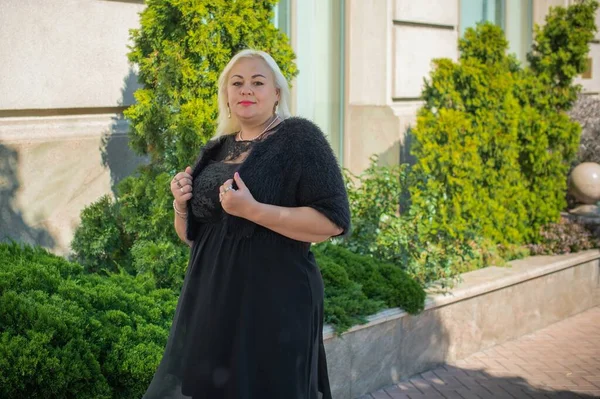 Artı cüsseli bir kadın, Amerikan ya da Avrupalı görünümlü bir kadın şehirde hayatın tadını çıkarıyor. Aşırı kilolu genç bir bayan, şehrin merkezinde şık bir şekilde giyinmiş. Doğal güzellik.