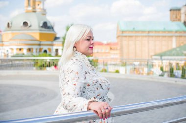 Artı cüsseli bir kadın, Amerikan ya da Avrupalı görünümlü bir kadın şehirde hayatın tadını çıkarıyor. Aşırı kilolu genç bir bayan, şehrin merkezinde şık bir şekilde giyinmiş. Doğal güzellik.