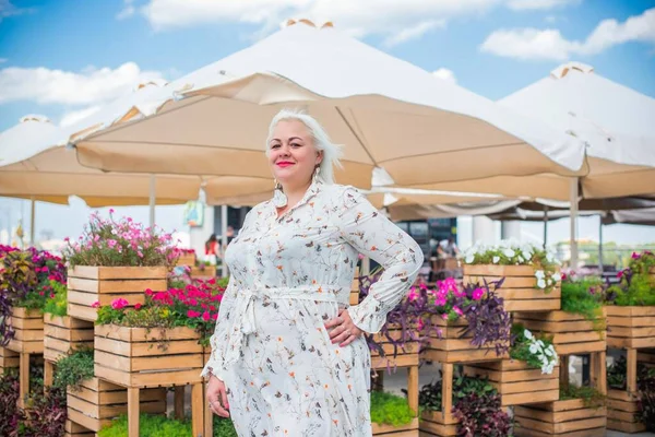 Artı cüsseli bir kadın, Amerikan ya da Avrupalı görünümlü bir kadın şehirde hayatın tadını çıkarıyor. Aşırı kilolu genç bir bayan, şehrin merkezinde şık bir şekilde giyinmiş. Doğal güzellik.