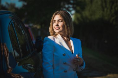 Sokakta beyaz ceketli bir kadın, kadın kıyafeti. Bayanlar için iş ve fantezi tarzı, moda ayrıntıları