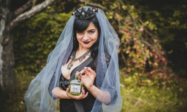 Mor peçeli gotik bayan Cadılar Bayramı için göz kamaştırıcı bir klasik. Klasik kıyafetler içinde güzel bir vatandaş. El yapımı güzel aksesuarlar. Cadılar Bayramı için fikirler