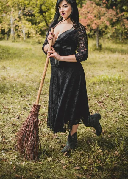 Cadılar bayramı için göz alıcı bir klasik görünümlü gotik kadın, süpürgeli bir cadı. Klasik kıyafetler içinde güzel bir vatandaş. El yapımı güzel aksesuarlar. Cadılar Bayramı için fikirler