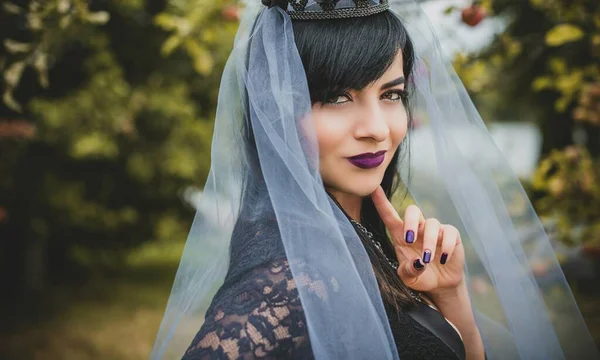 Mor peçeli gotik bayan Cadılar Bayramı için göz kamaştırıcı bir klasik. Klasik kıyafetler içinde güzel bir vatandaş. El yapımı güzel aksesuarlar. Cadılar Bayramı için fikirler