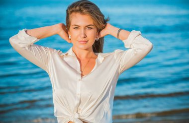 Dinlenme zamanı, zarif kadın plajda dinleniyor. Güzel kadınsı sarı saçlı bayan, sükunet ve özgürlük kavramı.