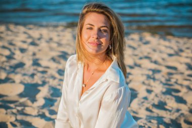 Dinlenme zamanı, zarif kadın plajda dinleniyor. Güzel kadınsı sarı saçlı bayan, sükunet ve özgürlük kavramı.