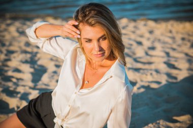 Dinlenme zamanı, zarif kadın plajda dinleniyor. Güzel kadınsı sarı saçlı bayan, sükunet ve özgürlük kavramı.