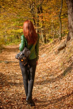 Sonbahar, doğa ve insan konsepti - kızıl saçlı genç güzel kadın sonbaharda dinleniyor. Oldukça iyi bir kadın gezgin rahatlar. Dağları sevmek, konsept macera açık havada aktif tatiller