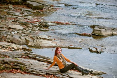 Sonbahar, doğa ve insan konsepti - kızıl saçlı genç güzel kadın sonbaharda dinleniyor. Oldukça iyi bir kadın gezgin rahatlar. Dağları sevmek, konsept macera açık havada aktif tatiller