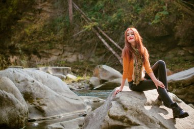 Sonbahar, doğa ve insan konsepti - kızıl saçlı genç güzel kadın sonbaharda dinleniyor. Oldukça iyi bir kadın gezgin rahatlar. Dağları sevmek, konsept macera açık havada aktif tatiller