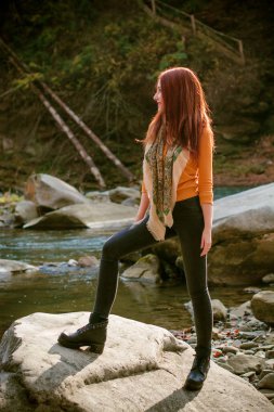 Sonbahar, doğa ve insan konsepti - kızıl saçlı genç güzel kadın sonbaharda dinleniyor. Oldukça iyi bir kadın gezgin rahatlar. Dağları sevmek, konsept macera açık havada aktif tatiller