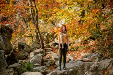 Sonbahar, doğa ve insan konsepti - kızıl saçlı genç güzel kadın sonbaharda dinleniyor. Oldukça iyi bir kadın gezgin rahatlar. Dağları sevmek, konsept macera açık havada aktif tatiller
