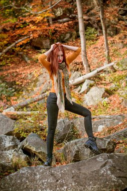 Sonbahar, doğa ve insan konsepti - kızıl saçlı genç güzel kadın sonbaharda dinleniyor. Oldukça iyi bir kadın gezgin rahatlar. Dağları sevmek, konsept macera açık havada aktif tatiller