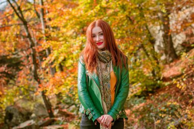 Sonbahar, doğa ve insan konsepti - kızıl saçlı genç güzel kadın sonbaharda dinleniyor. Oldukça iyi bir kadın gezgin rahatlar. Dağları sevmek, konsept macera açık havada aktif tatiller