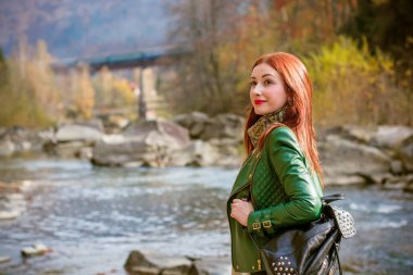 Sonbahar, doğa ve insan konsepti - kızıl saçlı genç güzel kadın sonbaharda dinleniyor. Oldukça iyi bir kadın gezgin rahatlar. Dağları sevmek, konsept macera açık havada aktif tatiller