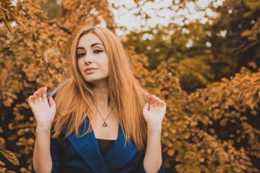 Sonbahar kadınları moda, şık makyaj ve saç stili. Klasik tonlarda kadın portresi. Mavi kürklü kızıl saçlı kadın.