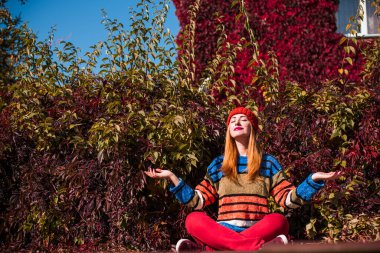 Sonbahar altın zamanı, şık bir kadının portresi kalın giysiler giyer, parkta sahne alır.