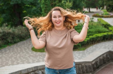 Mutlu gülümseyen güzel ve büyük beden modeli. Güneşli bir günde gülümseyen büyük bir kız portresi, yeni çağın standart güzelliğinin fotoğrafı.