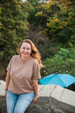 Mutlu gülümseyen güzel ve büyük beden modeli. Güneşli bir günde gülümseyen büyük bir kız portresi, yeni çağın standart güzelliğinin fotoğrafı.