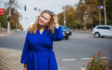 Mutlu gülümseyen güzel ve büyük beden modeli. Güneşli bir günde gülümseyen büyük bir kız portresi, yeni çağın standart güzelliğinin fotoğrafı.