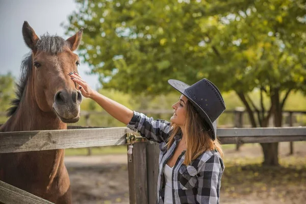 在马场上的美国女人一个戴着牛仔帽 骑着马的女孩的画像 大自然的希波疗法 — 图库照片