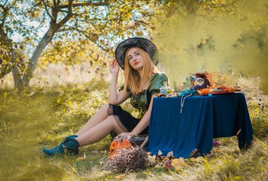 Bahçedeki mistik sahne, güzel cadı kadın, sihirli görünüş, Cadılar Bayramı fikirleri, kostüm.