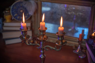 Mumlar sunakta yanar, mumlar arasında sihir, temiz negatif enerji, cadı kavramı.