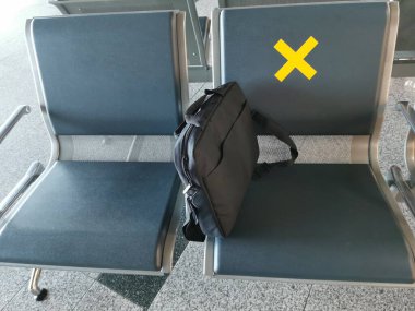 Havaalanındaki boş koltuklar ve işaretler. Coronavirüs salgını sırasında ya da covid-19 yeni normal konsept sırasında mesafe koymak