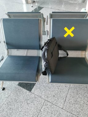 Havaalanındaki boş koltuklar ve işaretler. Coronavirüs salgını sırasında ya da covid-19 yeni normal konsept sırasında mesafe koymak