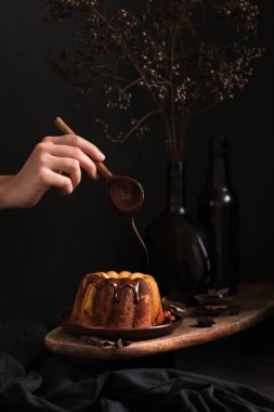 Paskalya 'da ya da Noel' de çikolatalı krema serpiştiren kadın eli.