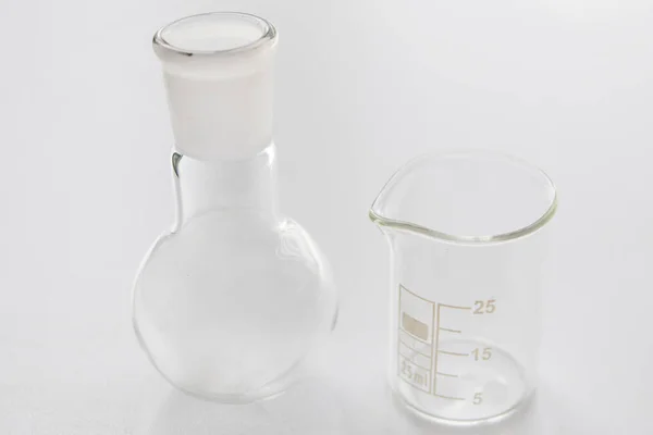 白地に隔離された化学研究所のための丸い底のフラスコとビーカー 研究室用ガラス製品科学の概念と底のフラスコとビーカー — ストック写真
