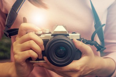 Retro film kamerası olan çok havalı bir Asyalı kadın ya da modern bahçe açık alışveriş merkezinde aynasız kamera..