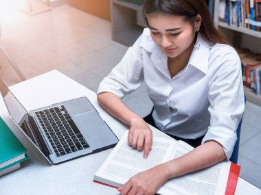 Asyalı öğrenciler kütüphanede ya da öğrenim merkezinde araştırma yapıyorlar.